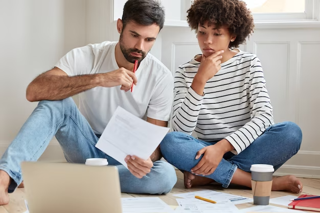 Image of a couple reviewing their finances, highlighting the importance of informed financial decisions in the face of rising rents and real estate choices