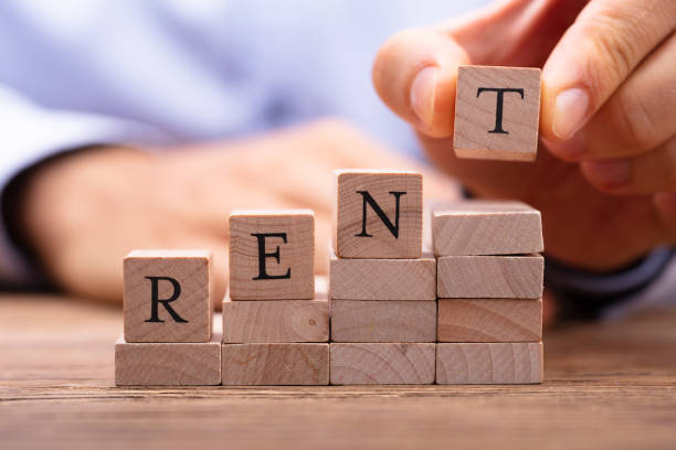 Wooden blocks forming the word 'RENT' - symbolizing challenges in the rental market.