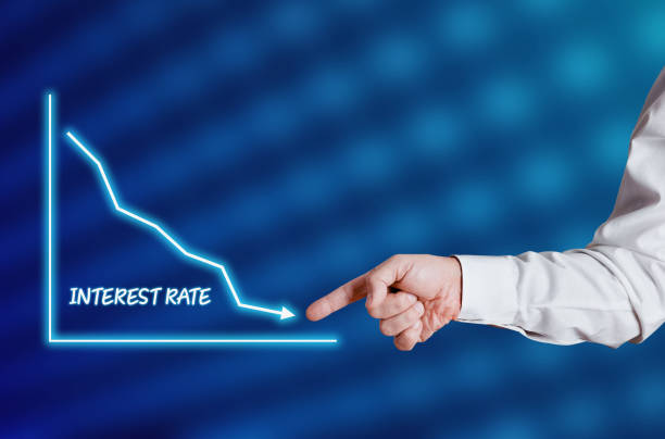 Hand pointing to a graph illustrating a downward trend in interest rates for 2024.