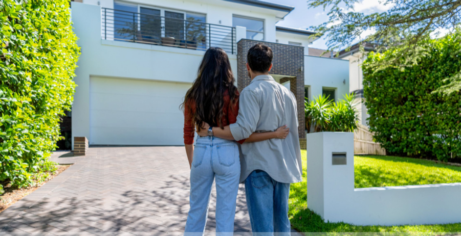 A couple examines a potential new home, contemplating their future. The decision to buy hinges not only on the property itself but also on the current cash rate, which can significantly impact their mortgage options and financial readiness.