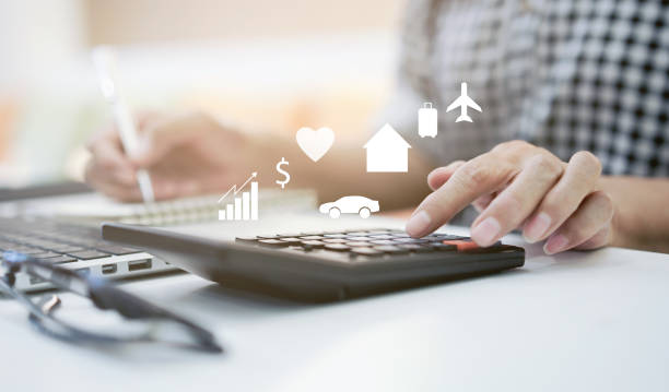 A person calculating their bills and expenses, representing the financial challenges home buyers face while managing rising living costs on their journey to homeownership.