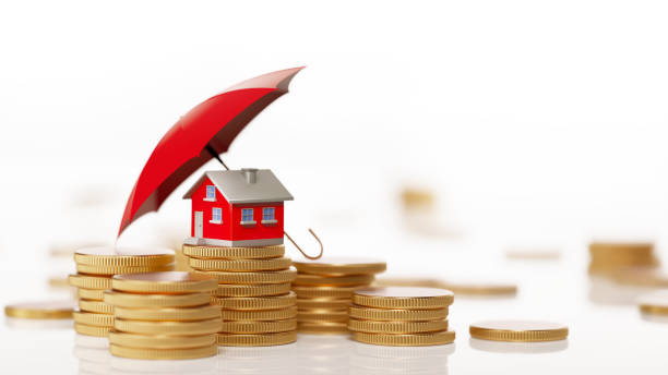 Red toy house behind a stack of coins under a red umbrella, symbolizing protection and financial security through insurance for homeowners.